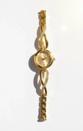 Elegant gold wristwatch with diamond accents and intricate bracelet design on white background