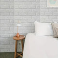 Minimalist bedroom corner with white brick wall, wooden side table, modern lamp, and white bedding