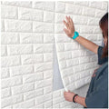 Person installing white 3D brick wall panels as decorative wallpaper on interior wall