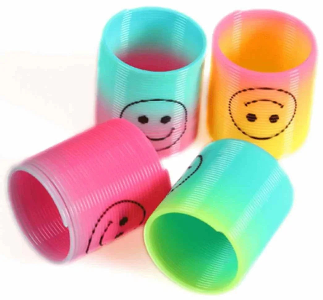 Colorful plastic coil spring toys with smiley face prints in pink, yellow, blue, and green