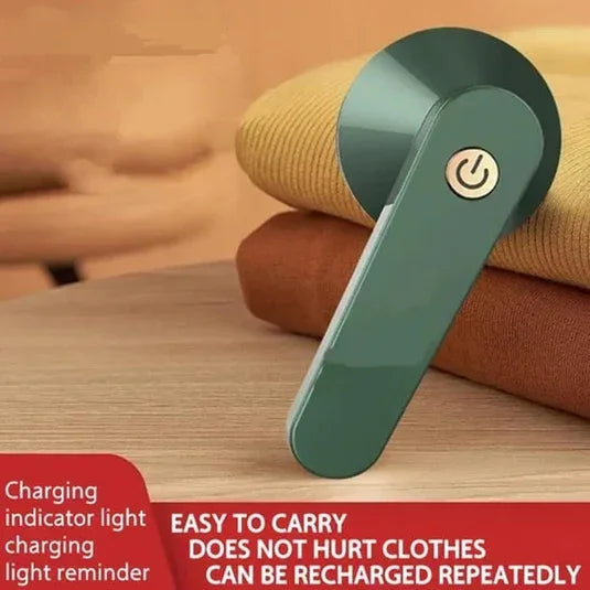 Compact handheld electronic fabric shaver with power button on folded sweaters